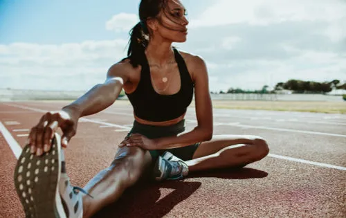 Athlete doing stretching exercises on running track